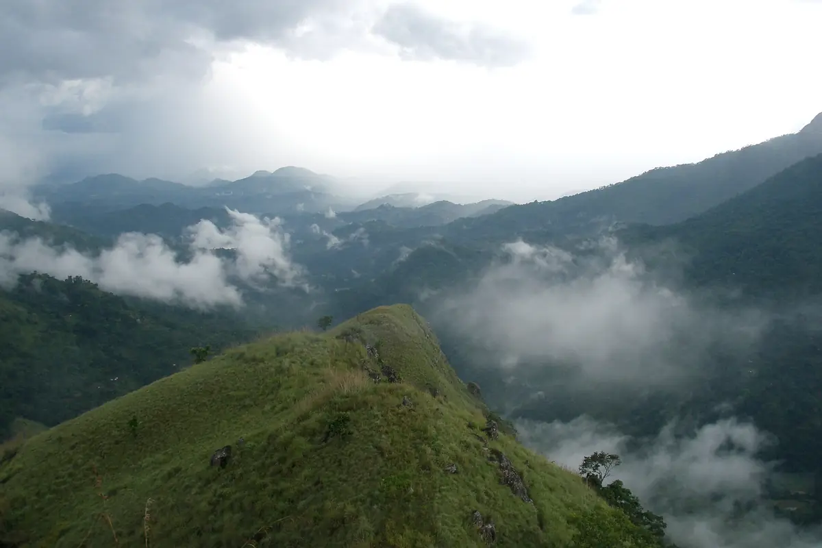 Clouds drifting through the Ella Gap between green mountain ridges